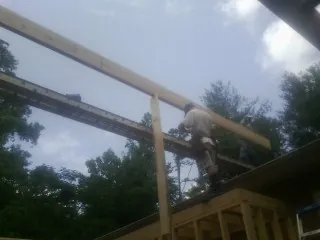 Carpenter setting a ridge beam over a new addition frame — Ice Dam Removal by Roofing Brothers in Cooksville
