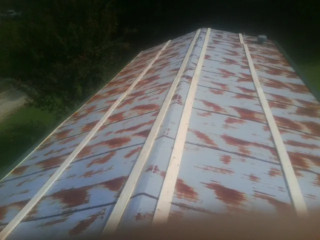 Rusted metal roof panels with new wood purlins before replacement — Storm Damage Roof Repair in Cooksville by Roofing Brothers