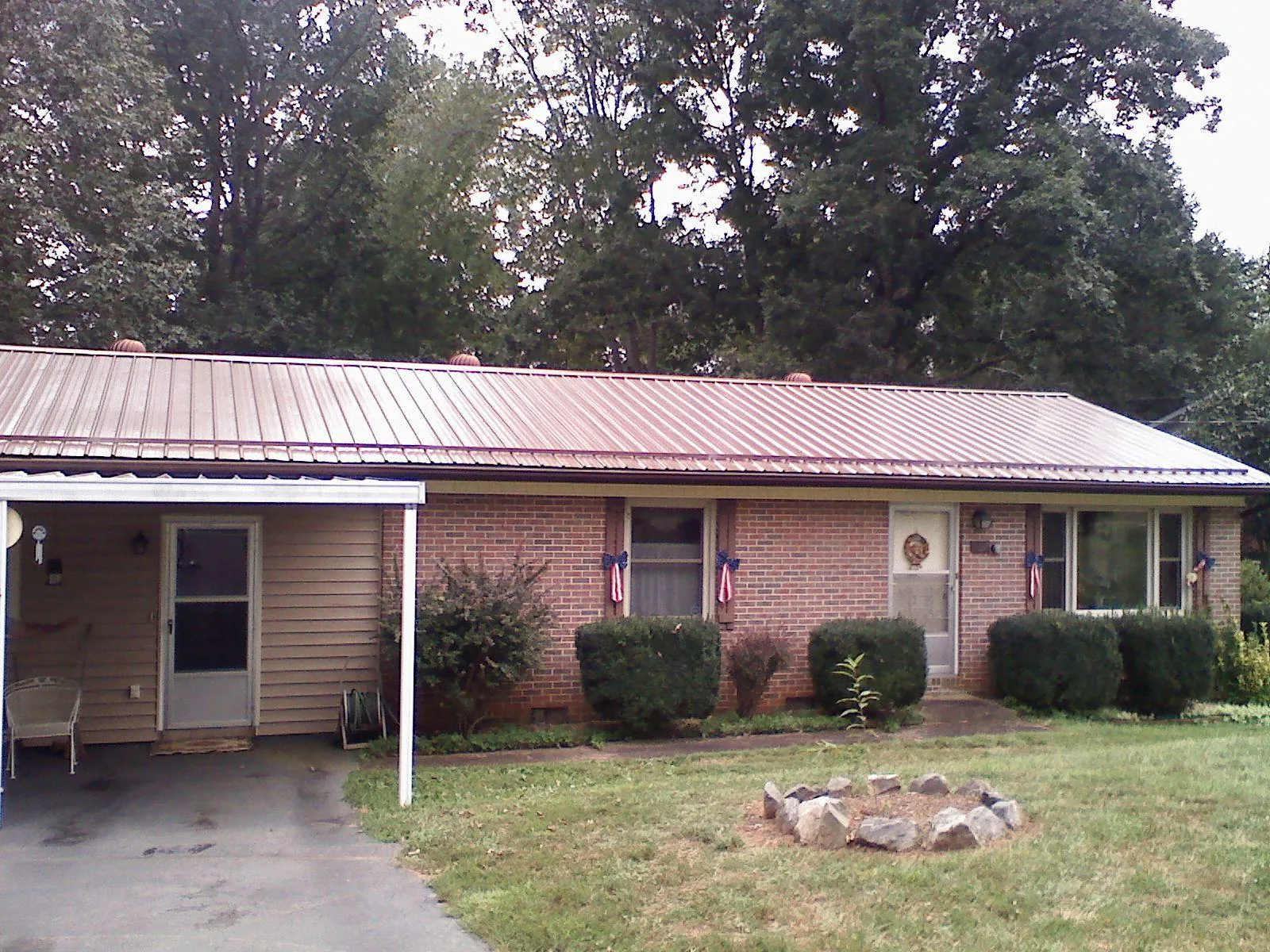 Bronze metal roof and carport on a brick ranch home — Roof Repair work by our crew in Cooksville